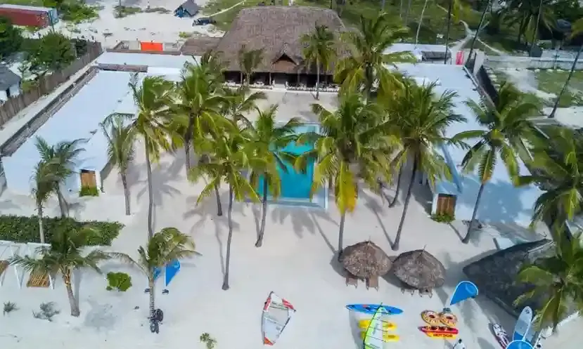 Pristine Jambiani Beach with turquoise waters and local fishing boats, showcasing relaxed vibes